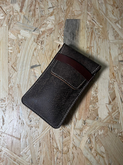 The SAMPLE SALE coffee brown premium pouch, featuring a brown strap, rests on a textured wooden surface, showcasing the elegance of personalization in sample-made pouches.
